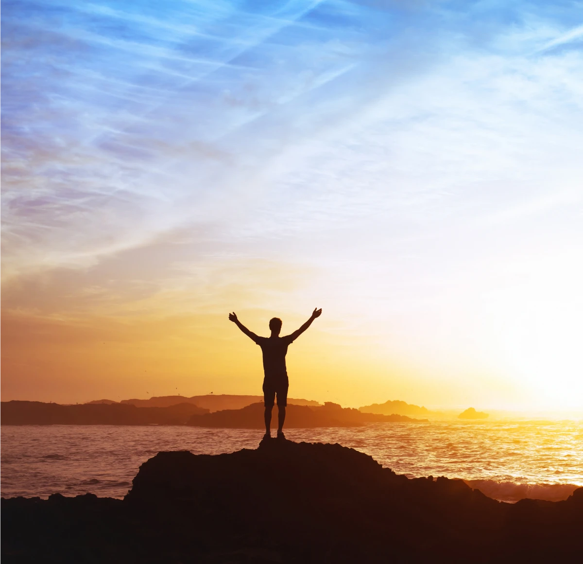 Individual standing triumphantly near ocean horizon