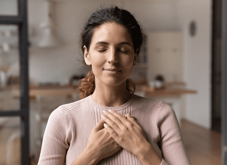 Woman meditating with hands on chest